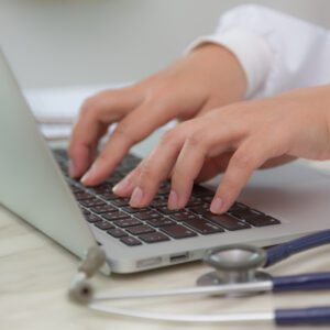 Doctor hands typing on laptop keyboard